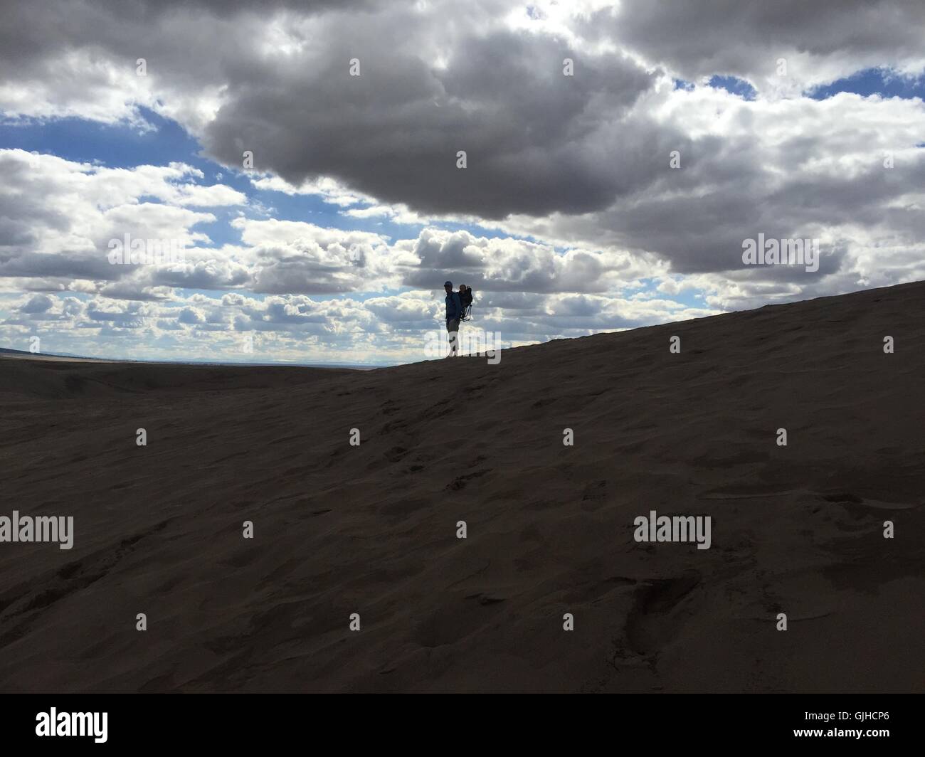 Silhouette di un padre che porta un figlio nello zaino, Great Sand Dunes National Park, Colorado, Stati Uniti Foto Stock