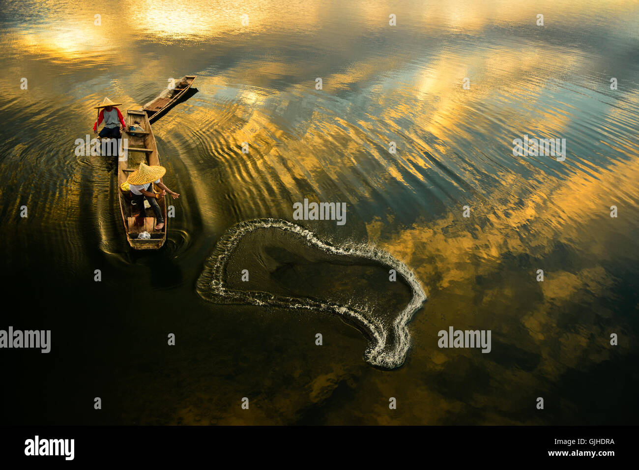 Due pescatori di una rete di colata nel fiume di sunrise, Thailandia Foto Stock