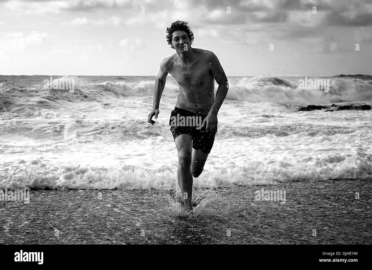 Uomo che corre sulla spiaggia Foto Stock