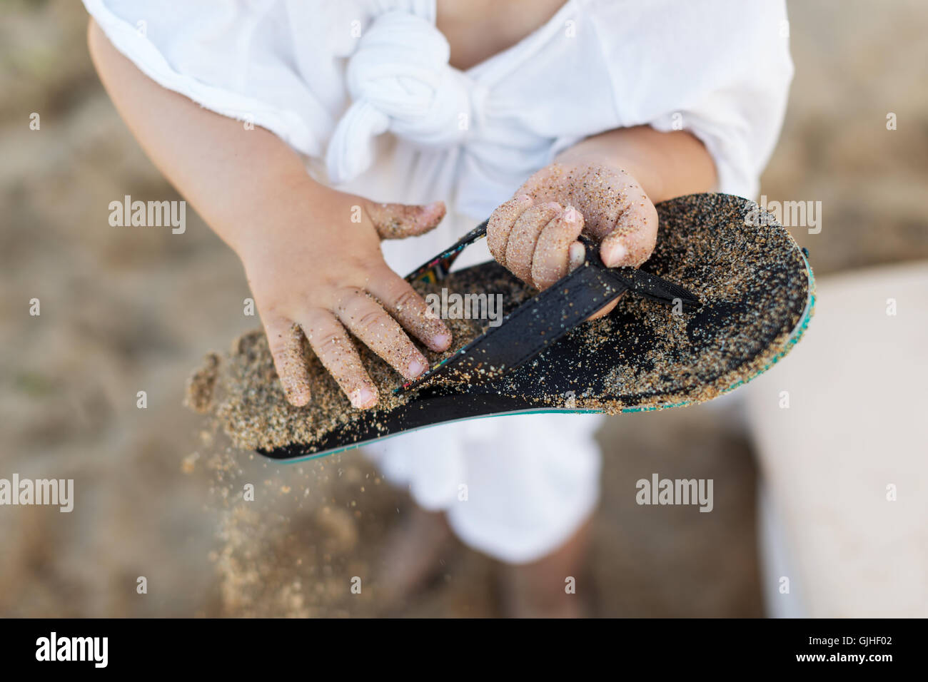 Close-up di un ragazzo di sabbia di spazzolatura off flip-flop Foto Stock