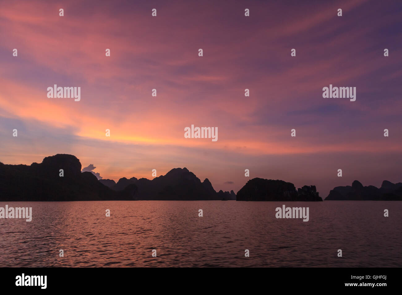 Silhouette di pietre calcaree carsiche al tramonto, la baia di Ha Long, Vietnam Foto Stock