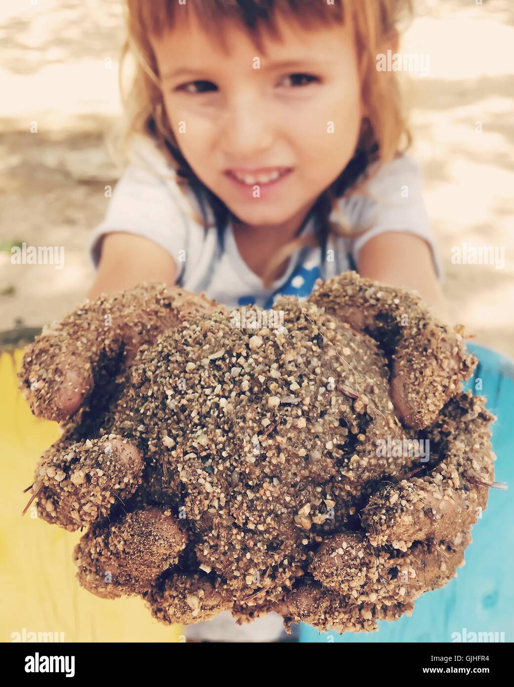 Ragazza con palla di fango nelle sue mani Foto Stock
