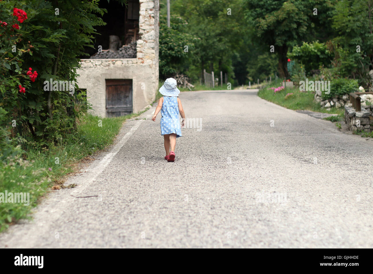 Vista posteriore della ragazza camminare lungo la strada di montagna, Schio, veneto, Italia Foto Stock