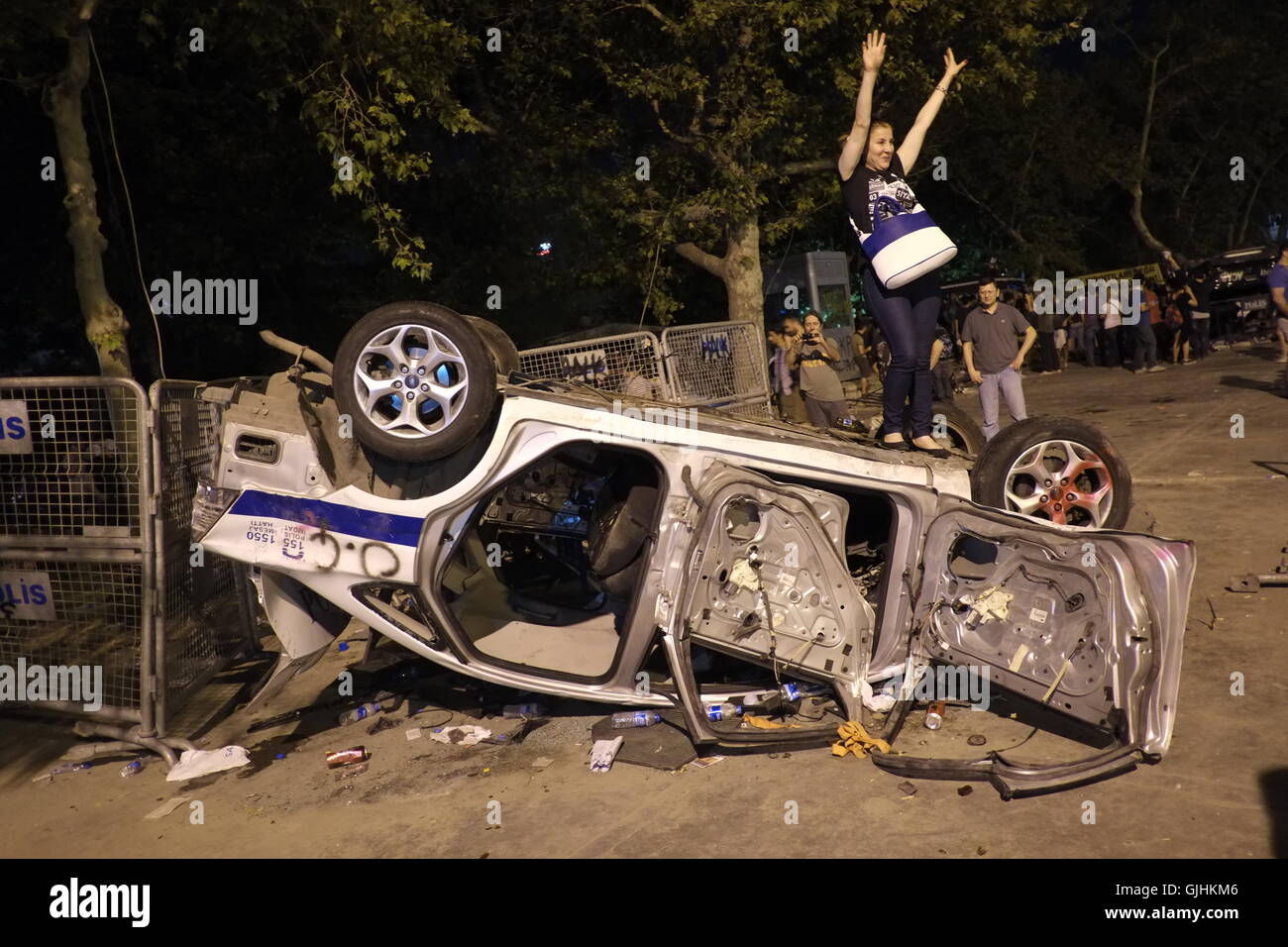 Donna in posa per una foto sul rovesciato auto della polizia durante la Istanbul Gezi park dimostrazioni. Foto Stock