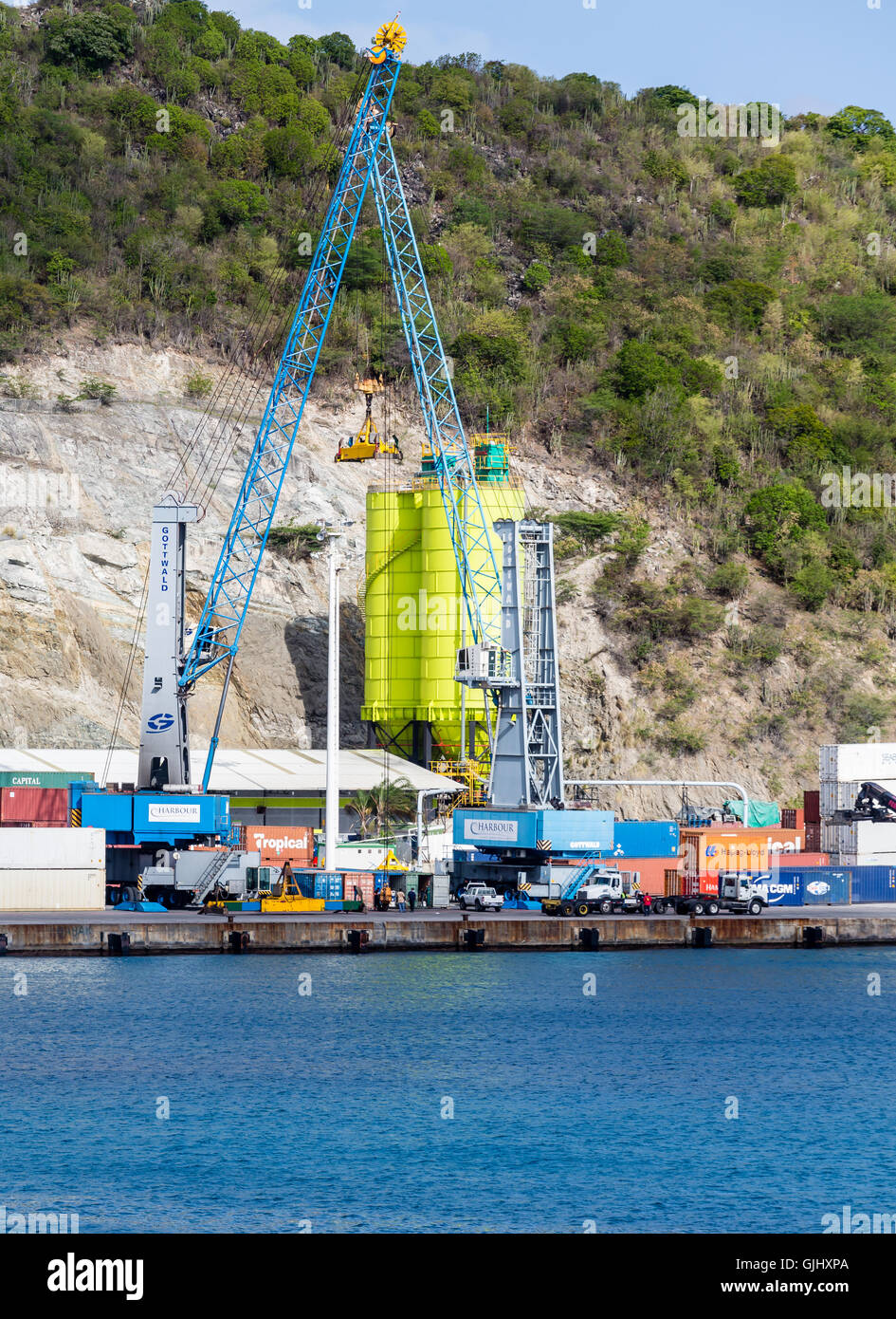 Una gru di colore blu e verde di un silo ad una operazione di spedizione su St Maarten Foto Stock