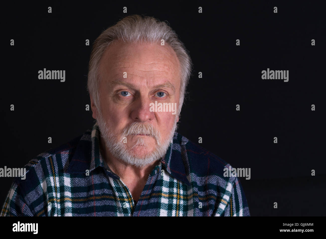 Ritratto di grigio-barbuto uomo caucasico con hard look Foto Stock