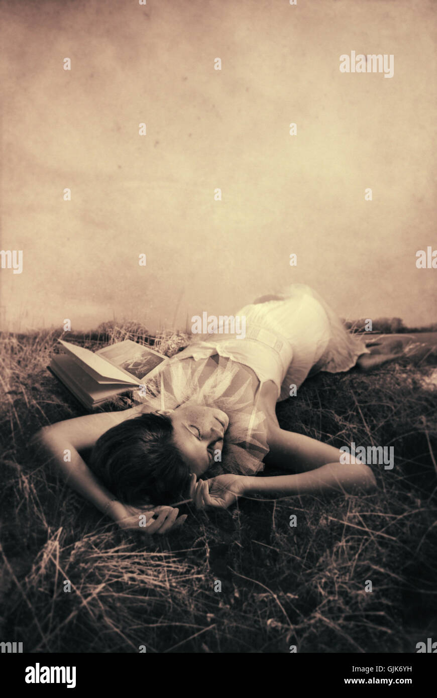 Giovane donna sdraiata su erba e dormire Foto Stock