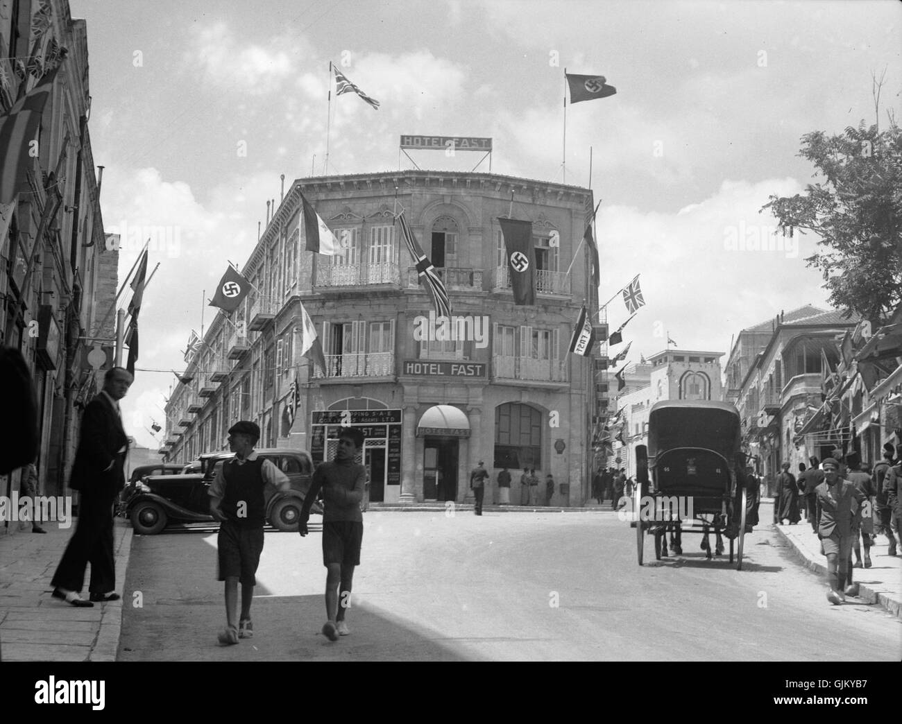 Questa fotografia cattura le bandiere britanniche e naziste che volano dal Fast Hotel, probabilmente scattate durante un significativo momento storico, riflettendo l'ambiente politico teso dell'epoca. Foto Stock
