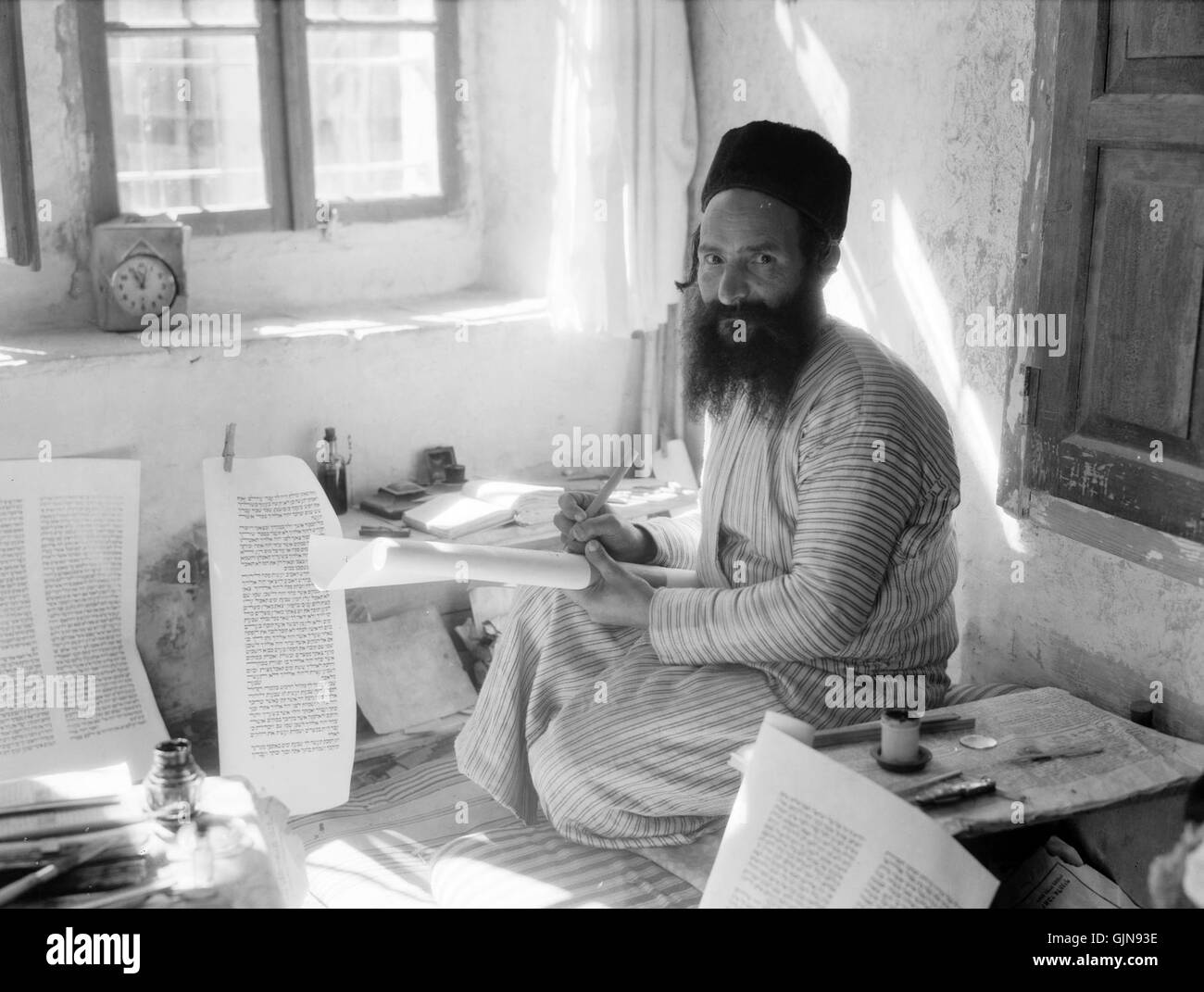 Questa immagine raffigura uno scriba ebreo meticolosamente che scrive la Torah, un'importante tradizione religiosa e culturale dell'Ebraismo. L'atto di trascrizione ha un significato storico, che riflette la conservazione dei testi sacri. Foto Stock