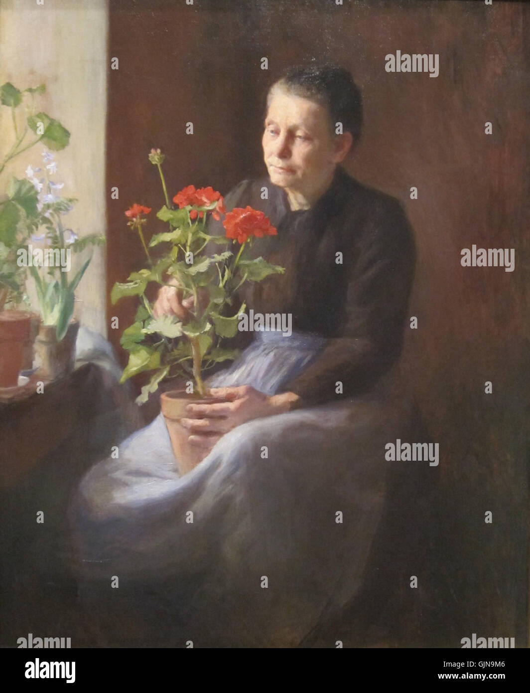 "Donna con gerani" di Caroline A. Lord è un dipinto ad olio che raffigura una donna circondata da vibranti fiori di geranio. Questo pezzo, in prestito al Cincinnati Art Museum, riflette l'attenzione di Lord sui temi domestici e naturali nella sua arte, catturando luce, colore e l'espressione contemplativa del soggetto. Foto Stock