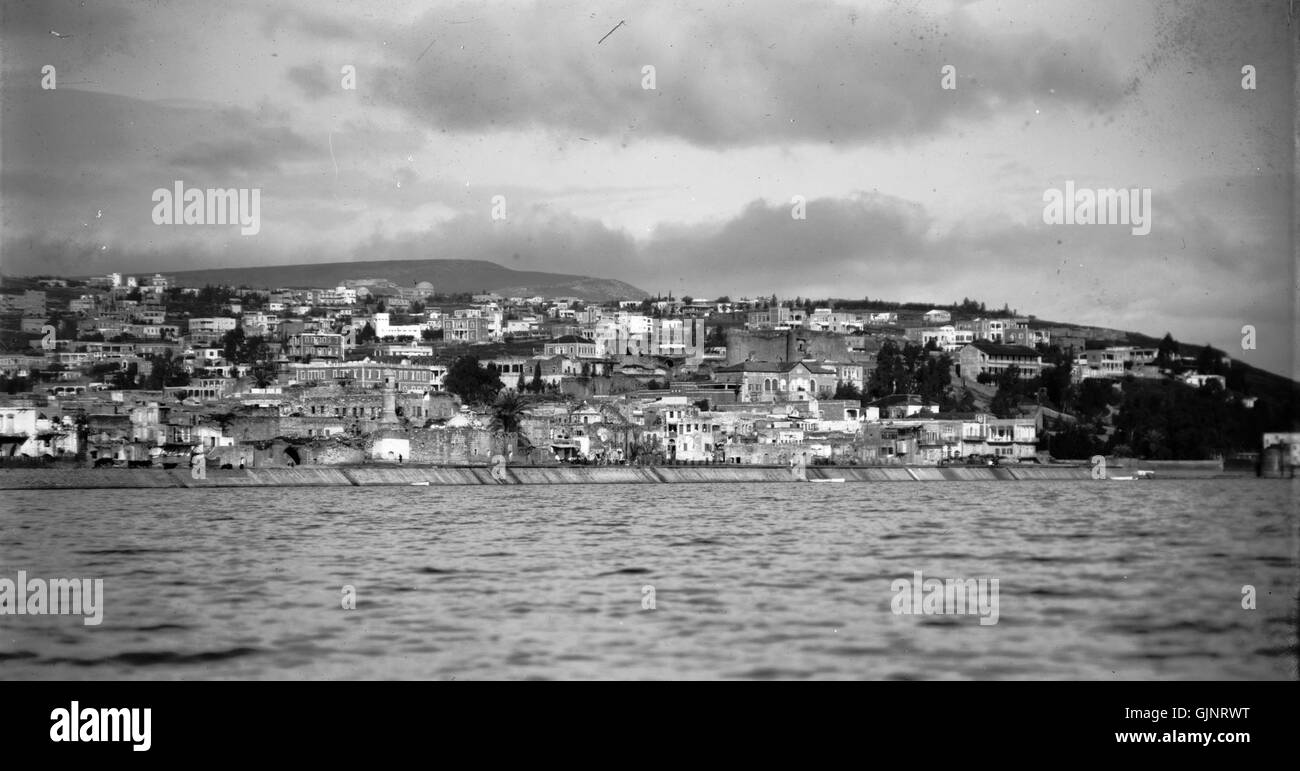 Questa fotografia cattura Tiberiade, Israele, dal lago di Galilea, scattata tra il 1934 e il 1939. Presenta il pittoresco paesaggio e l'ambientazione storica di questa importante città durante il periodo del mandato britannico. Foto Stock