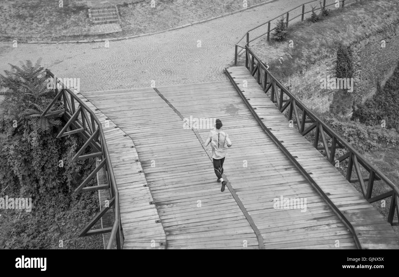 In bianco e nero un uomo correre jogging vista in elevazione dello schienale posteriore Foto Stock