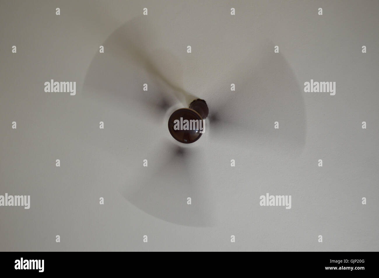 Una fotografia ad alta velocità di un ventilatore a soffitto rotante, scattata a 25° di una seconda esposizione. L'immagine mostra la sfocatura del movimento delle pale della ventola, sottolineando il movimento dinamico e la velocità di rotazione. Foto Stock
