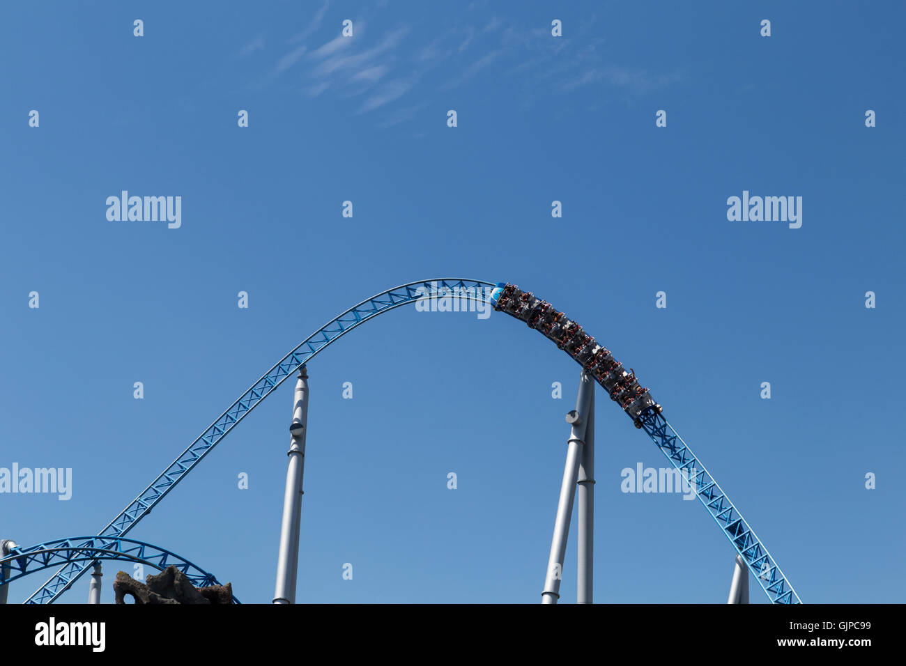 Blue roller coaster loop con il carrello nella parte anteriore del cielo blu Foto Stock