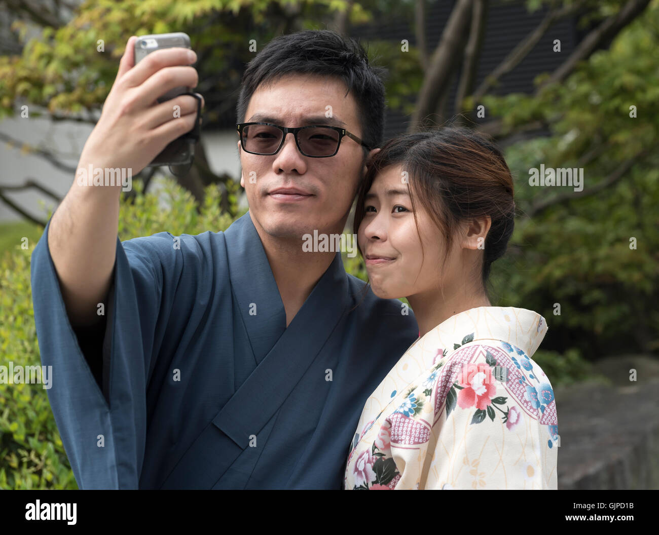 Giapponese giovane vestito nel tradizionale abito yukata prendere selfie, Tokyo, Giappone Foto Stock