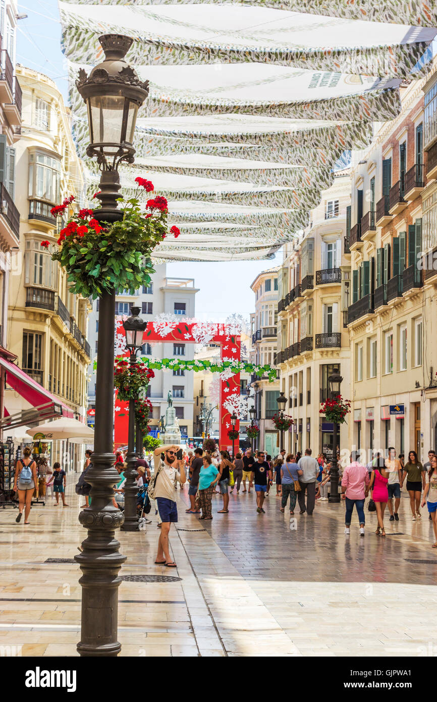Calle Marques de Larios, Malaga, Costa del Sol, Andalusia, Spagna. Pedoni passeggiare sotto ombrose tende da sole Foto Stock