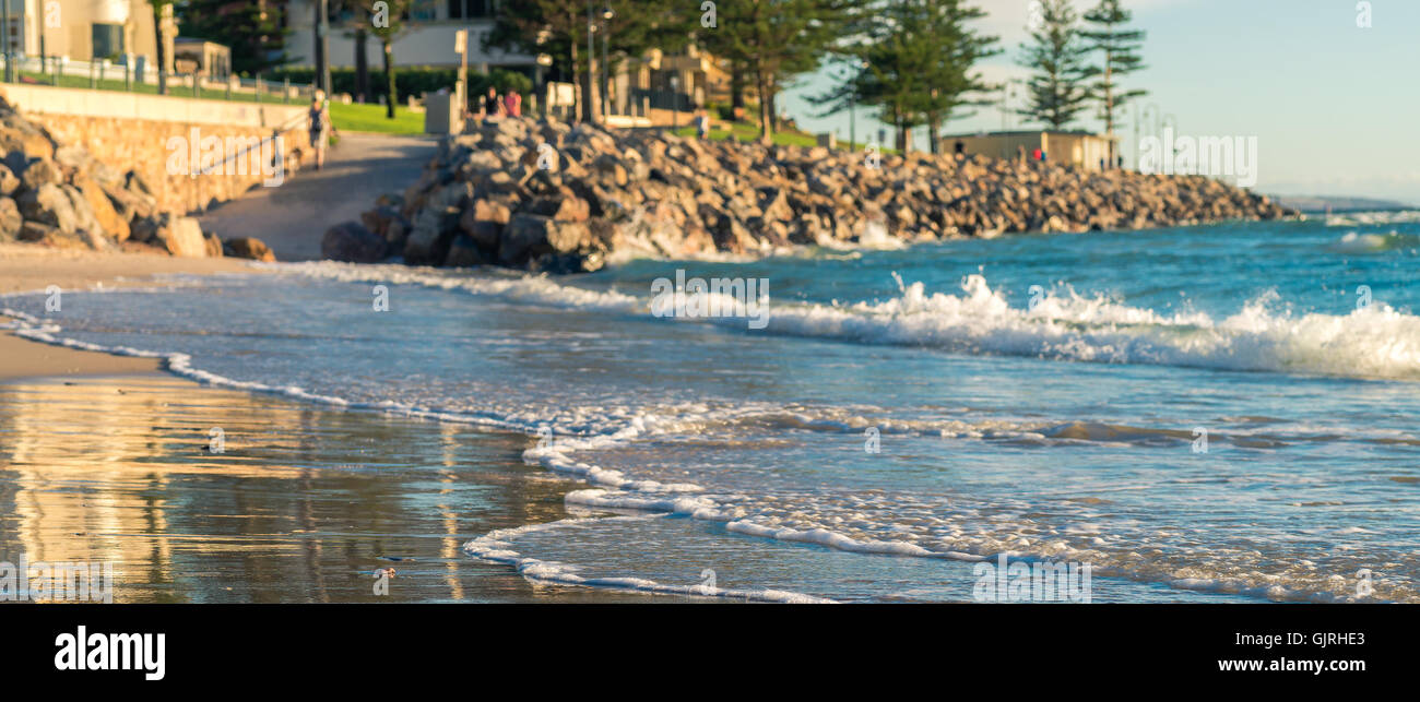 Lavaggio onde la spiaggia di Glenelg su un giorno d'estate. Sfocare lo sfondo con colore-tonificante applicato Foto Stock