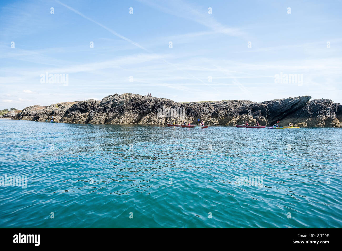 Canoa intorno alle rocce di Rhoscolyn, Anglesey, Galles del Nord in una giornata di sole. Foto Stock