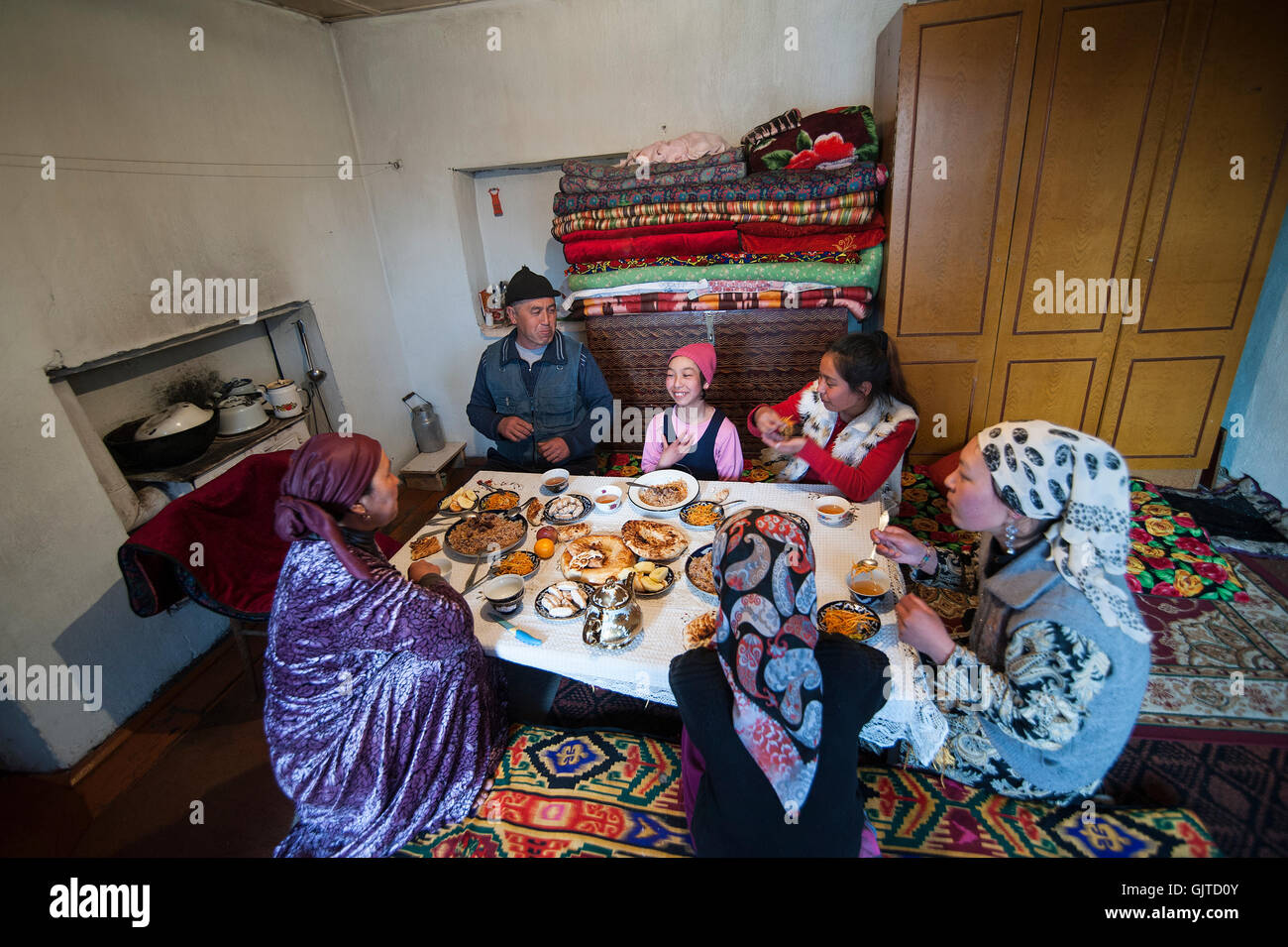 Kirghizistan,Jalabat: famiglia sta avendo la cena, il riso con un po' di soddisfare, insalata, pane tipico e tè verde e dolci. Foto Stock