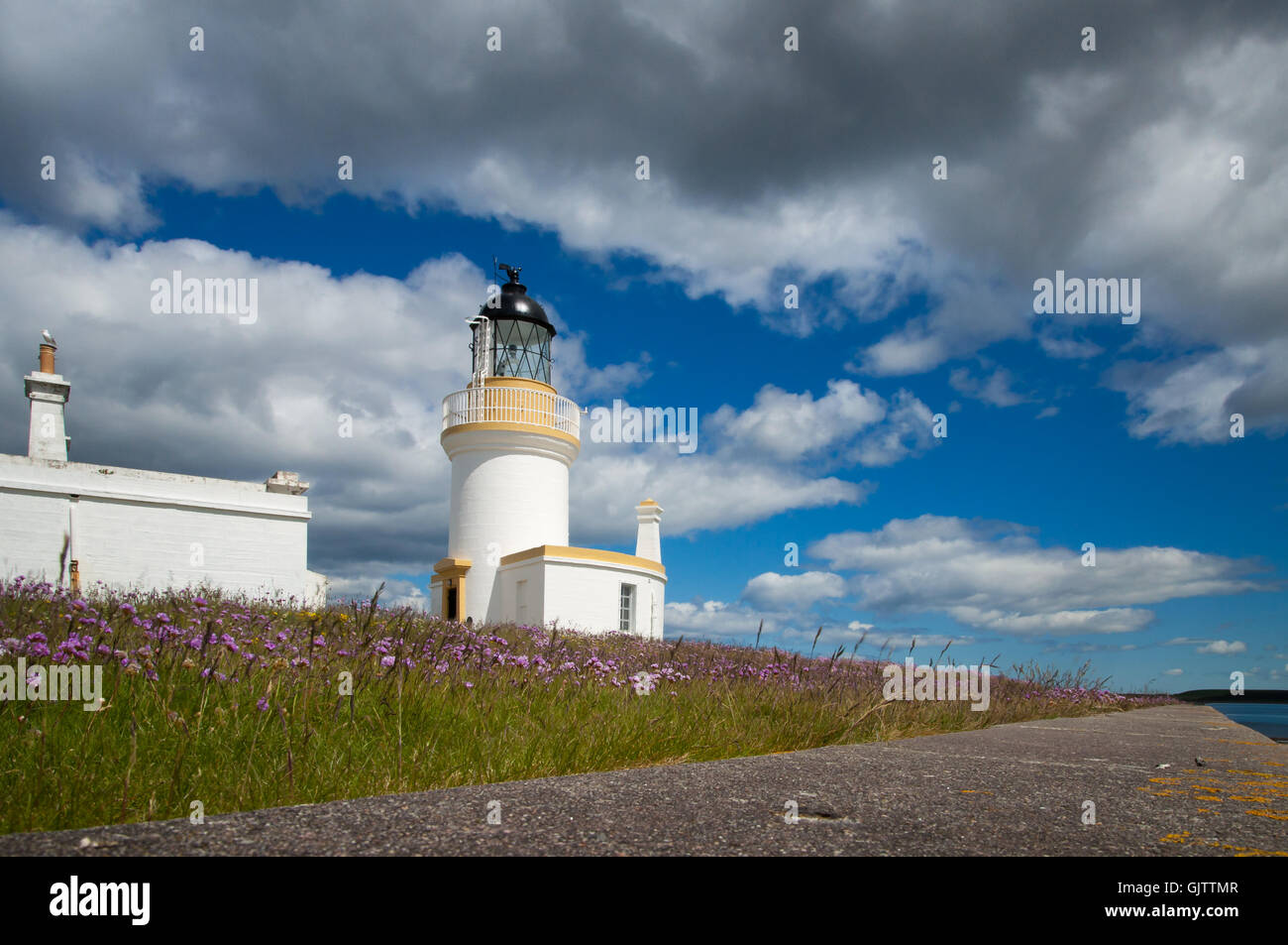 Un vecchio faro a Chanonry Point. Sotto le nuvole scure. Foto Stock