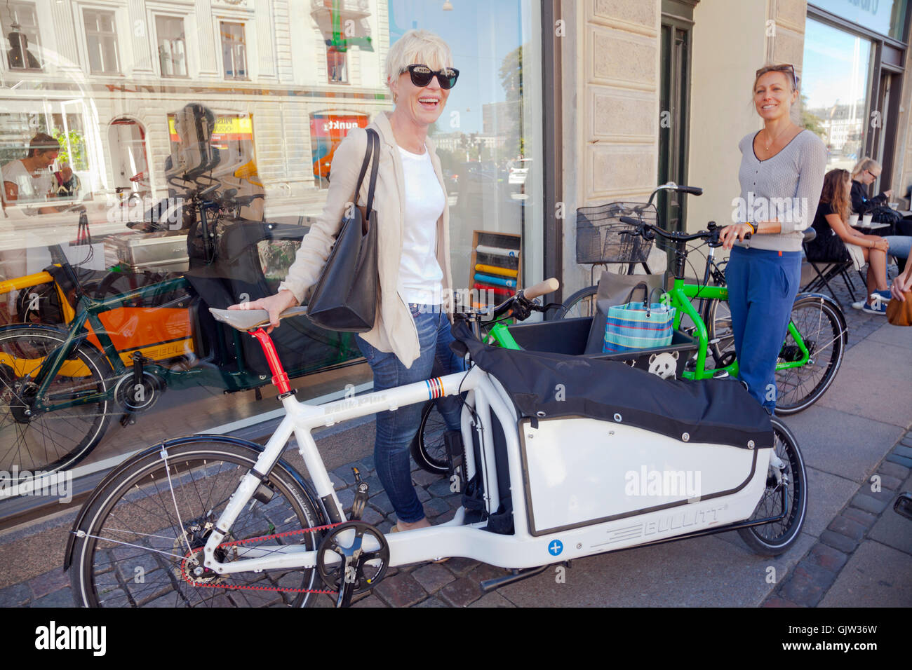 Due giovani donne con i loro amati Bullitt cargo bike al di fuori del Larry vs. Harry, Bullitt negozio di Copenhagen. La Danimarca. Foto Stock