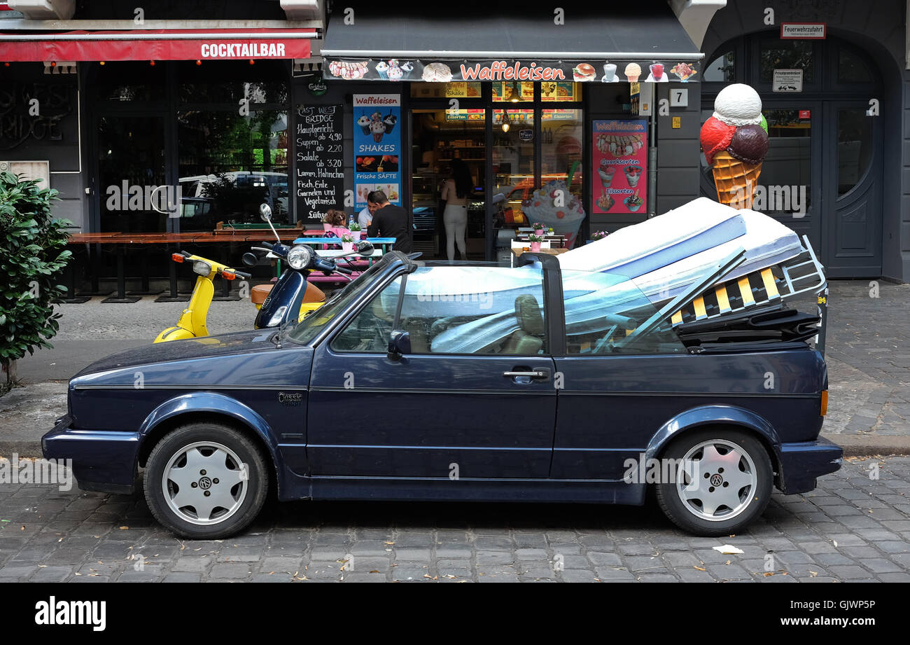Berlino, Germania. 17 Ago, 2016. Un convertibile è caricato con un letto e materassi in Simon-Dach-Strasse a Berlino, Germania, 17 agosto 2016. Foto: Jens KALAENE/DPA/Alamy Live News Foto Stock