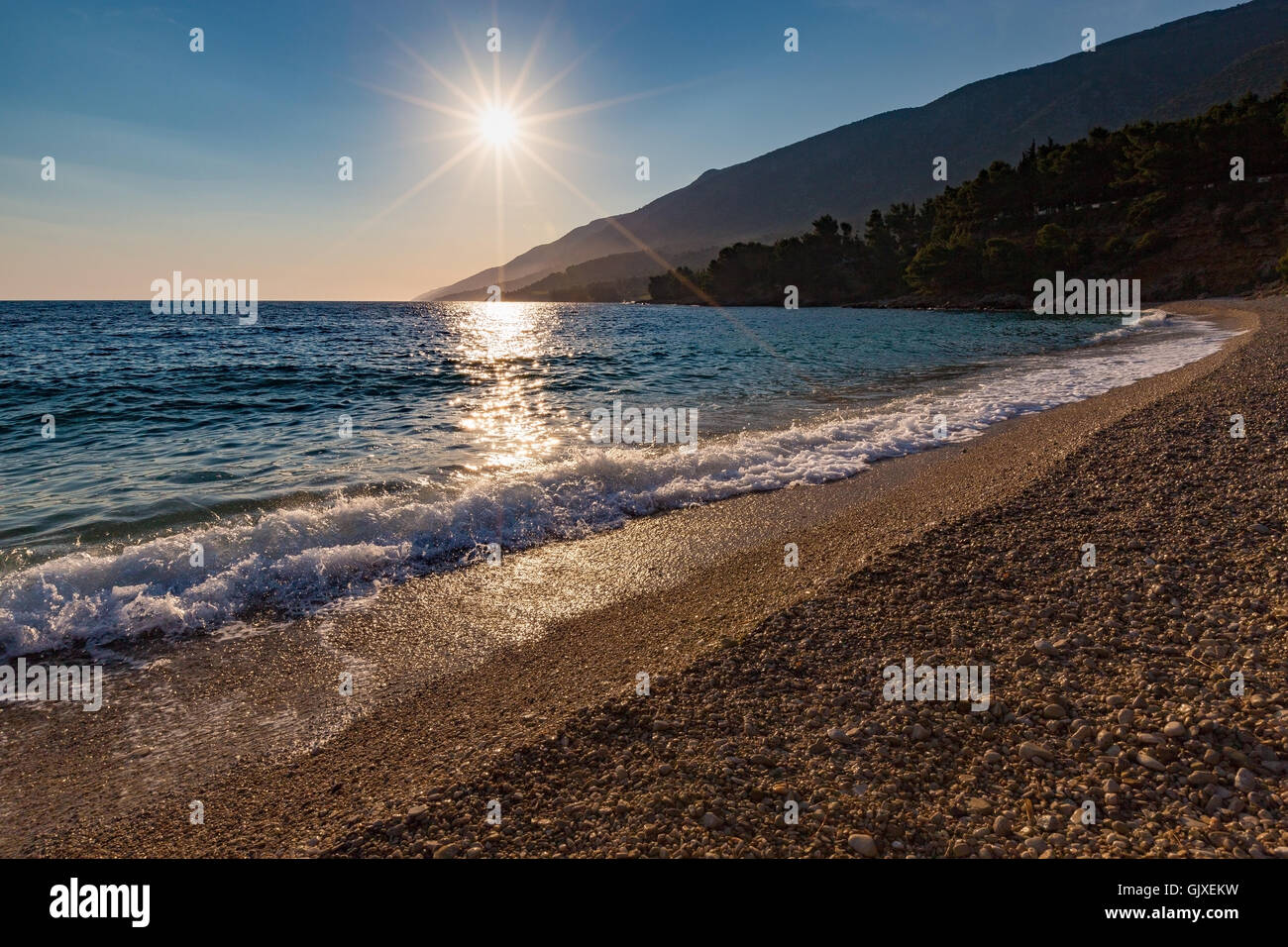 Retroilluminazione al tramonto. Onda del mare Adriatico. Spiaggia di Zlatni Rat. Bol, isola di Brac, Croazia. Europa. Foto Stock