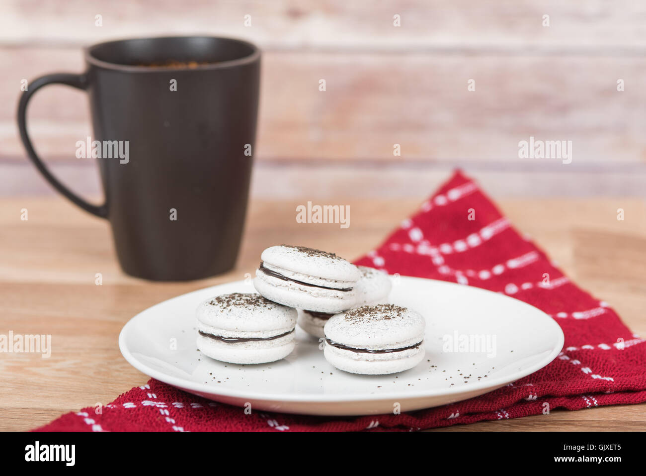 White macarons sulla piastra con la tazza di caffè in background Foto Stock