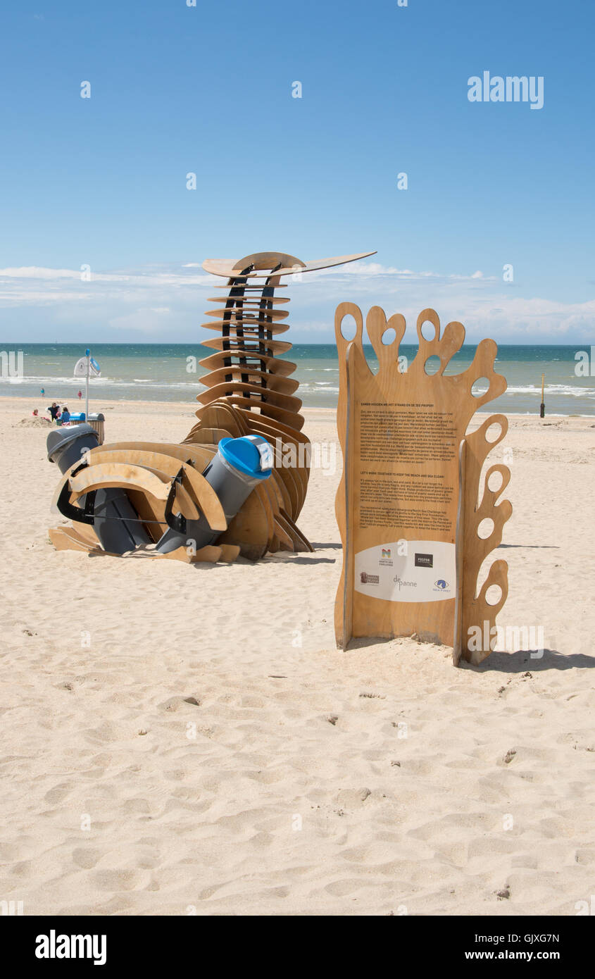 Una scultura promuove la consapevolezza ambientale sulla spiaggia ed in mare mentre la combinazione di due cassonetti per rifiuti. Foto Stock