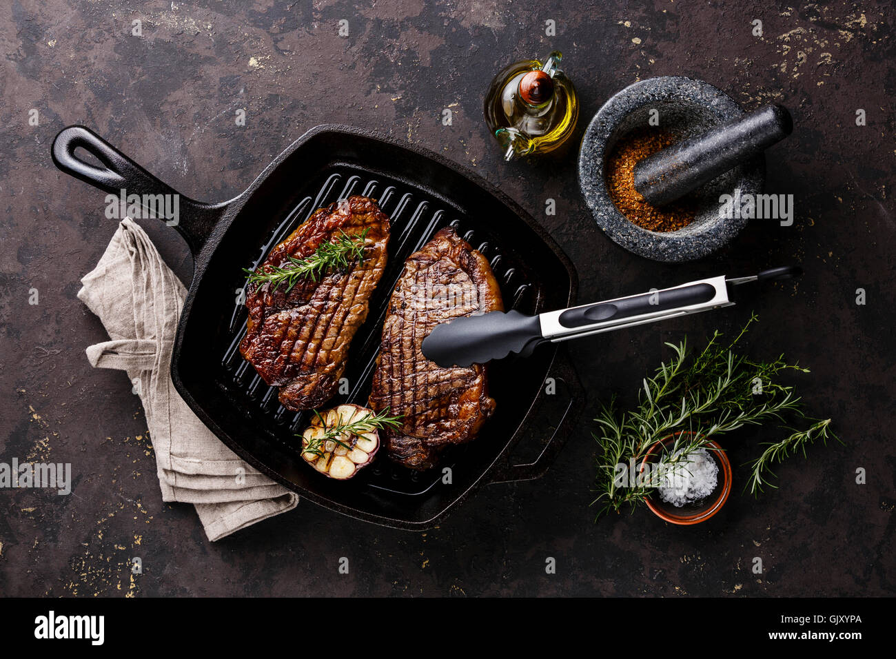 Grigliata di Black Angus Bistecca di controfiletto su frittura ghisa padella per grigliare su sfondo scuro Foto Stock
