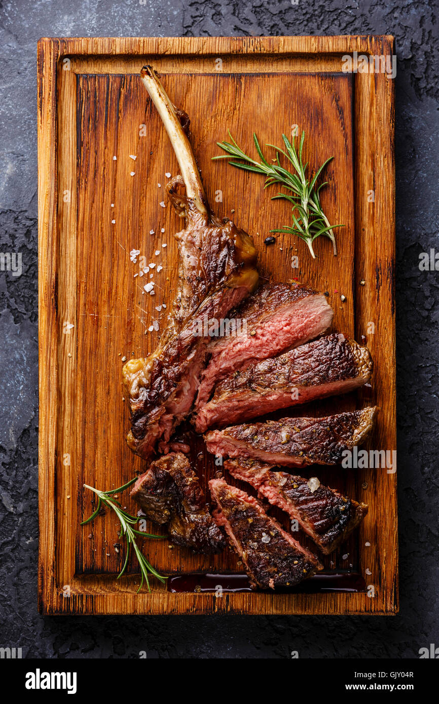 Tagliate a fette grigliate di mezzo raro barbecue Steak su ossa bovine nervatura su sfondo scuro Foto Stock