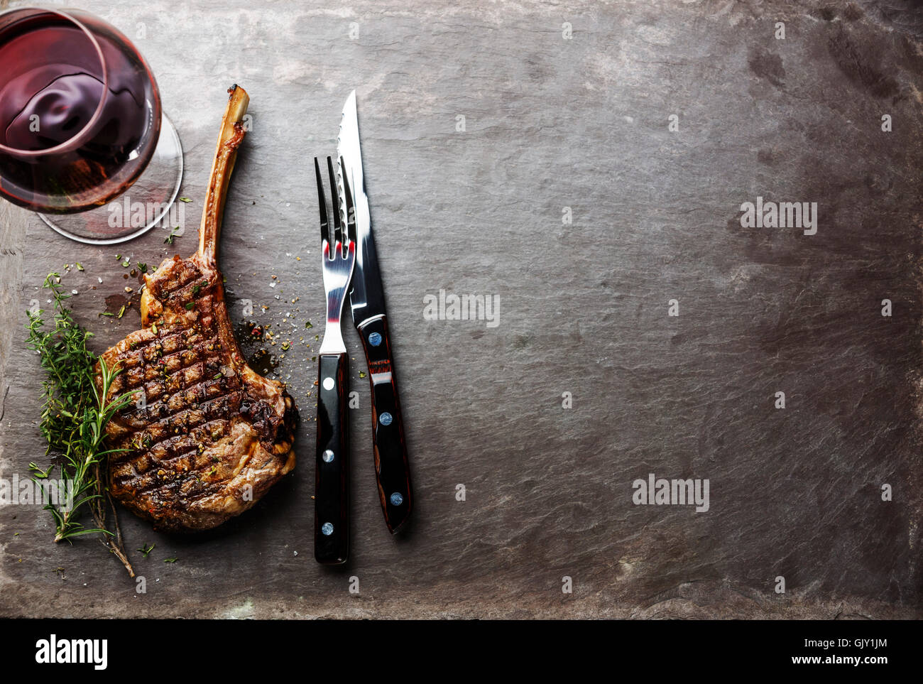 Manzo alla griglia barbecue di carne di vitello Bistecca di nervatura sul  tessuto osseo e il vino sulla pietra sullo sfondo di ardesia Foto stock -  Alamy