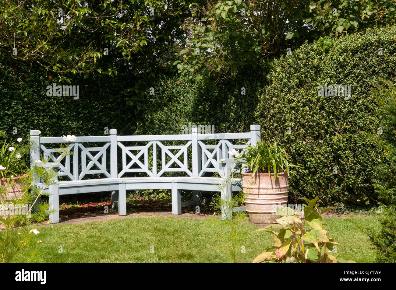 Mobili da giardino. Banco in un area con posti a sedere di un giardino formale Foto Stock