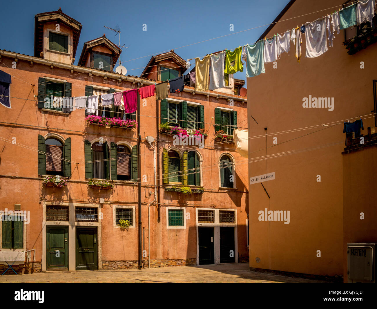Edifici tradizionali con i veneziani persiane e persiane alle finestre, con servizio lavanderia appesi da un lavaggio in linea. Venezia, Italia. Foto Stock
