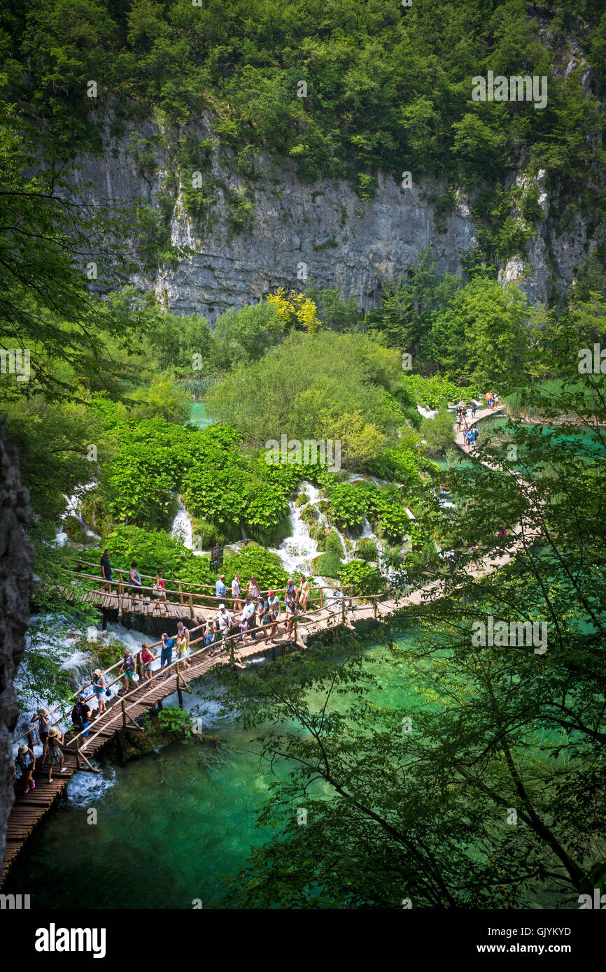 I turisti a passeggiare sulle passerelle in legno rivestito da petasites, lungo il fiume Korana (Parco Nazionale dei Laghi di Plitvice - Croazia). Foto Stock