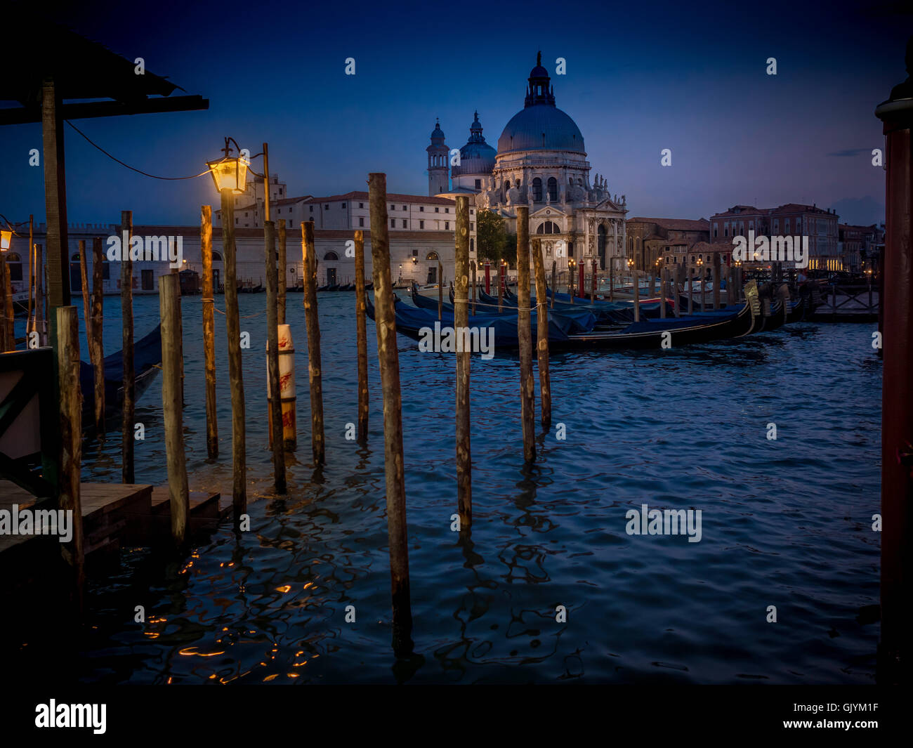 Gondole attraccate per la notte sul Canal Grande, con la chiesa di Santa Maria della Salute in background. Venezia, Italia., Foto Stock