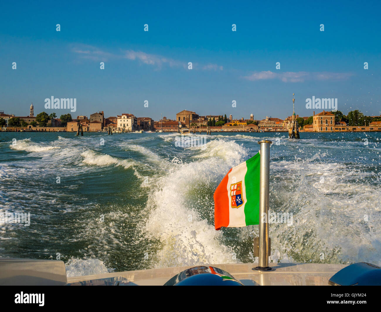 Bandiera Italiana sulla poppa di un acqua taxi, viaggia a velocità. Venezia, Italia. Foto Stock