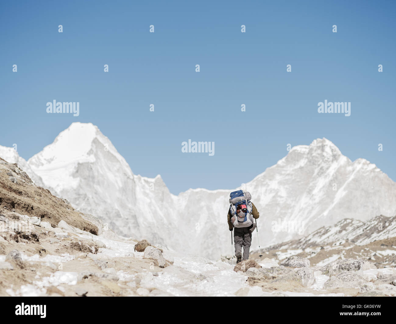 Un escursionisti fa il suo modo attraverso la coperta di neve Himalaya sul suo campo base Everest viaggio Foto Stock