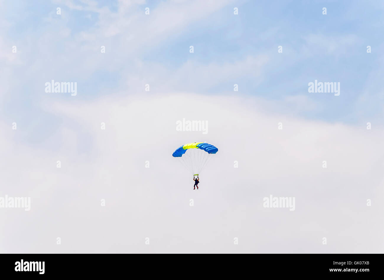 Parachutist sull'aria, è l'atterraggio, dopo che egli ha scavalcato da un piccolo aereo. Uomo di volare tra le nuvole. Giornata di sole dell'estate. Foto Stock