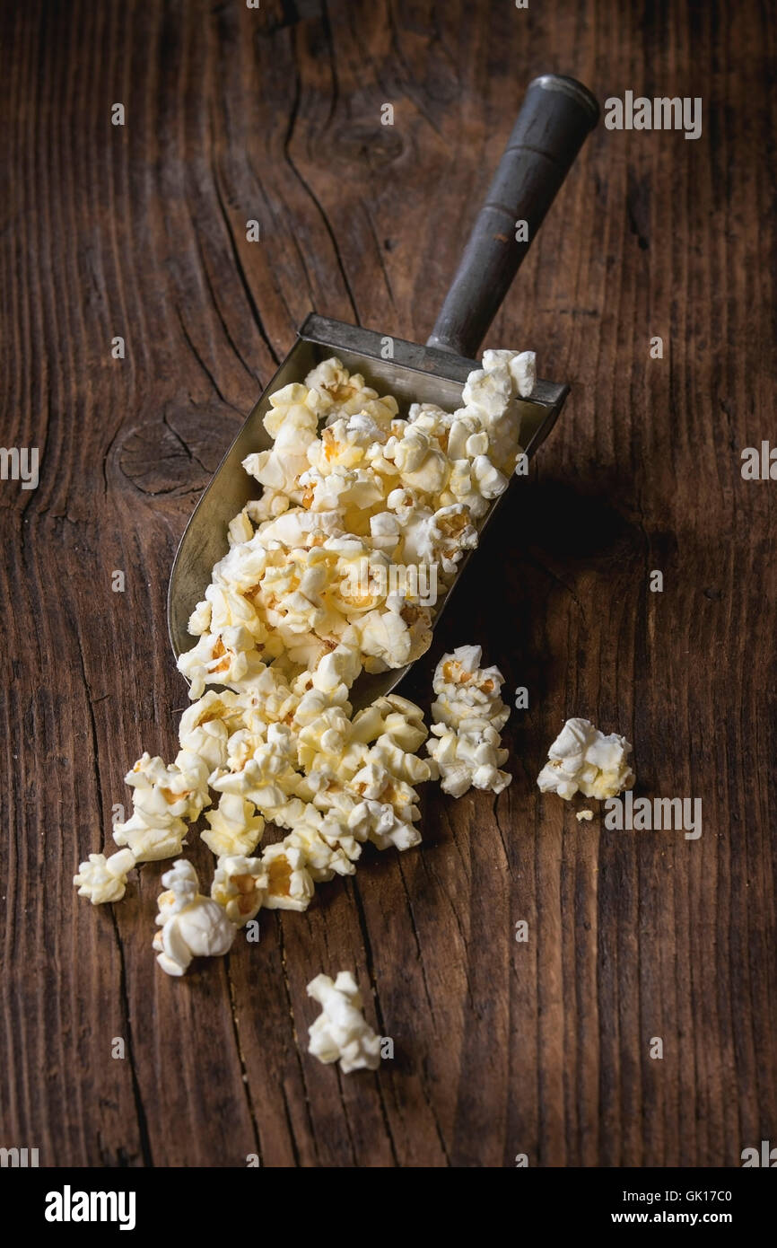 Preparate popcorn salata nella vecchia convogliatore in alluminio su legno scuro dello sfondo. Con spazio di copia Foto Stock