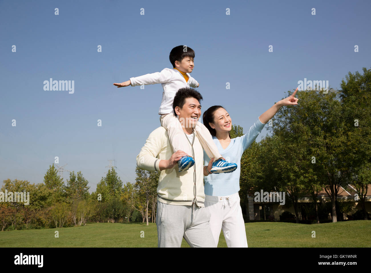 Una famiglia di tre giochi nel giardino Foto Stock