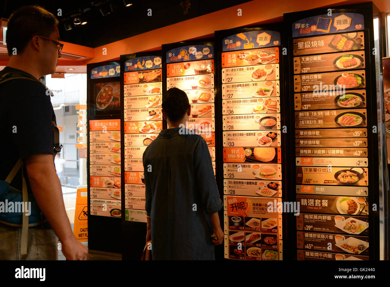 Stile di Hong Kong ristoranti fast food. Il menu viene visualizzato su una parete d'ingresso, i clienti ordinano al cassiere. Foto Stock