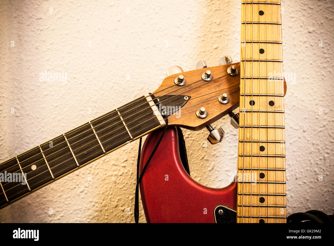 Primo piano di due colli di chitarra sulla parete dello sfondo. Vintage filtrata Foto Stock