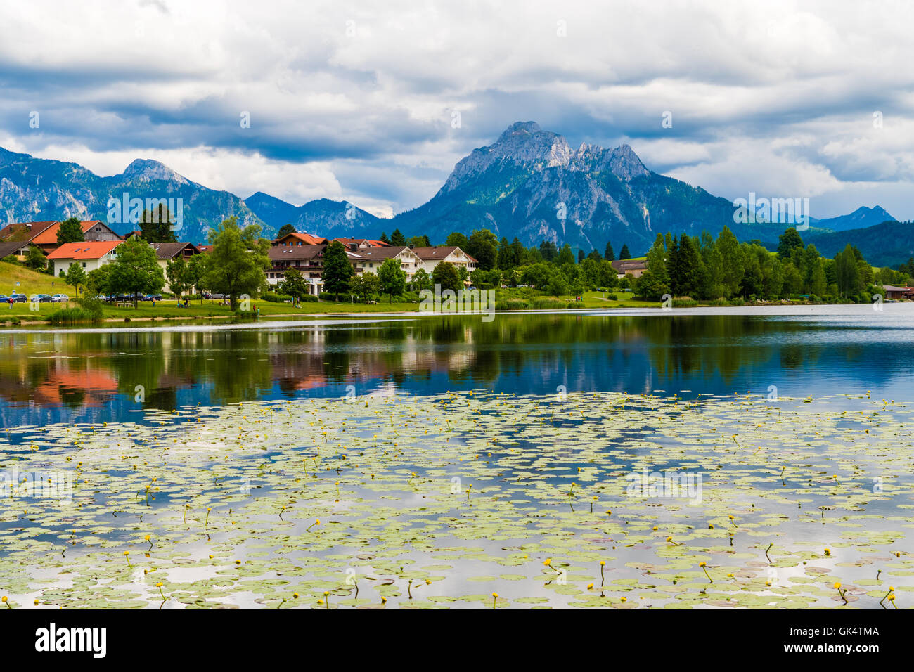 Un villaggio vicino al lago e monti all'orizzonte Foto Stock