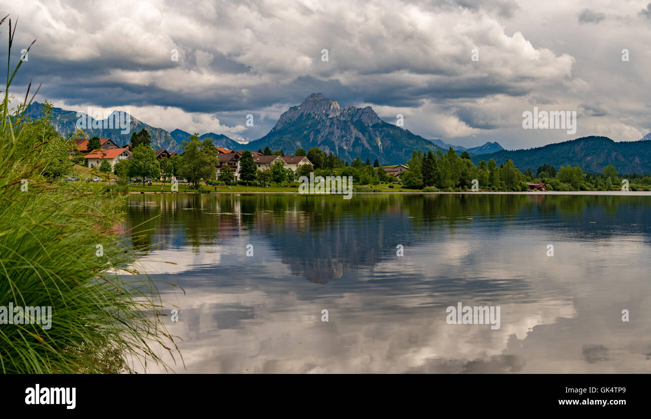 Un villaggio vicino al lago e monti all'orizzonte Foto Stock