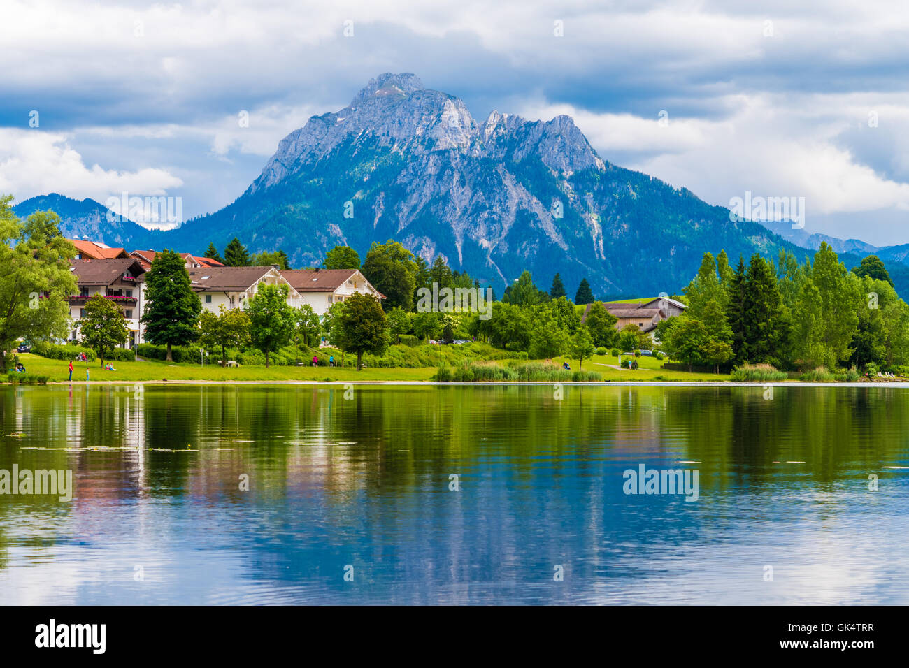 Un villaggio vicino al lago e monti all'orizzonte Foto Stock
