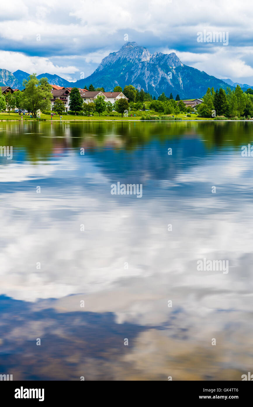 Un villaggio vicino al lago e monti all'orizzonte Foto Stock