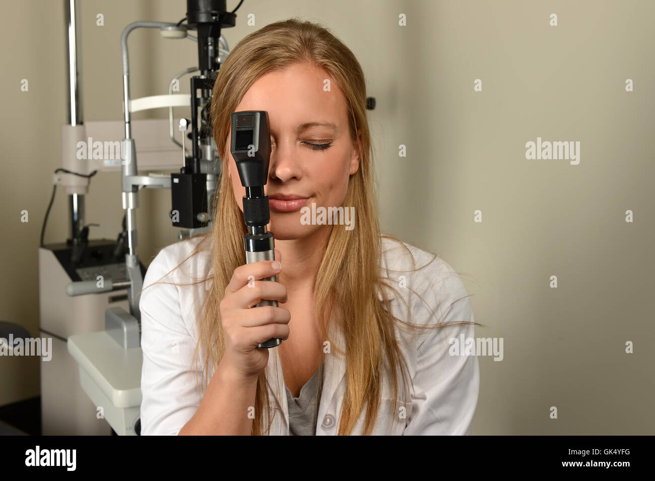 Occhio femminile medico di eseguire l'esame all'interno di office Foto Stock