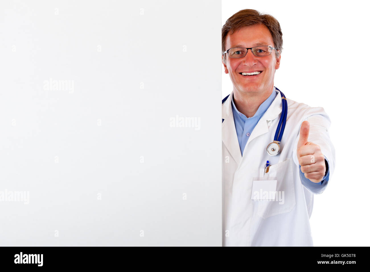Sorridente medico con uno spazio pubblicitario detiene il pollice in alto. Foto Stock