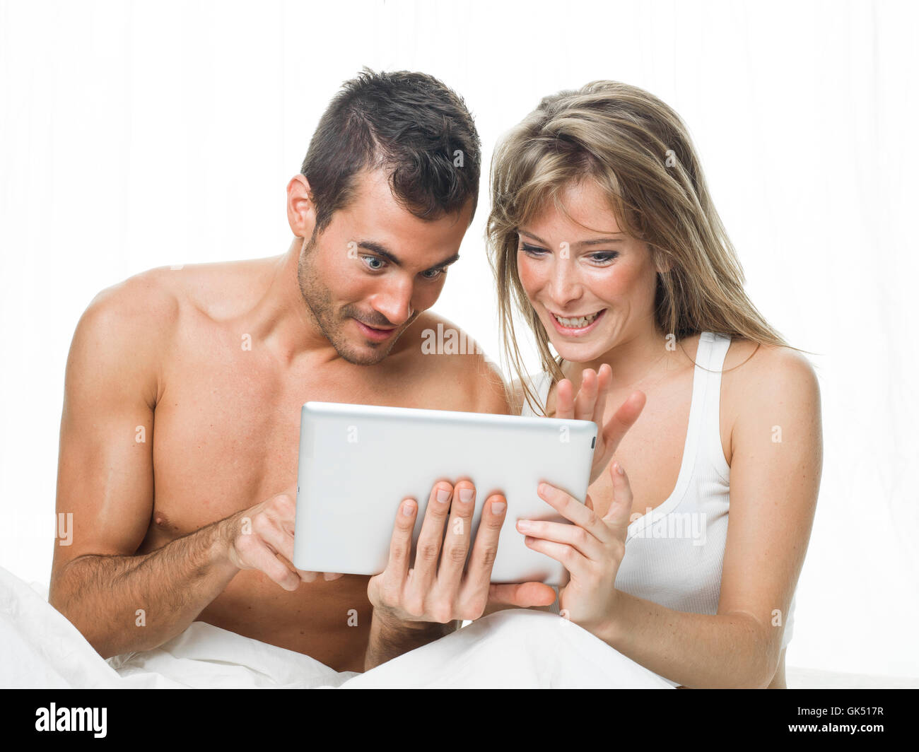 Coppia attraente guardare le cose in una compressa Foto Stock